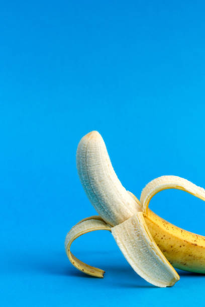 istock Peeled banana on blue background. Copy space. 1370870536