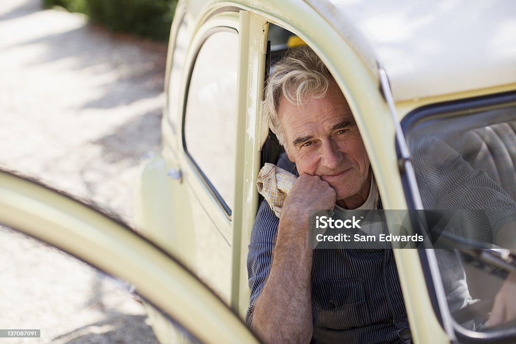 Ritratto di sorridente uomo anziano con la mano sul mento in - Foto stock royalty-free di 60-64 anni