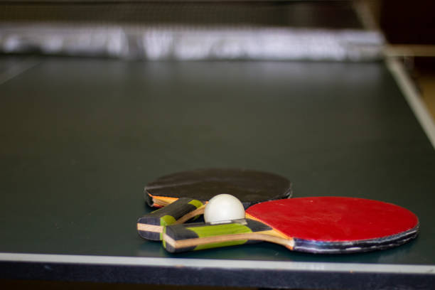 istock Two ping-pong rackets and a ball lie on a green table 1370871216