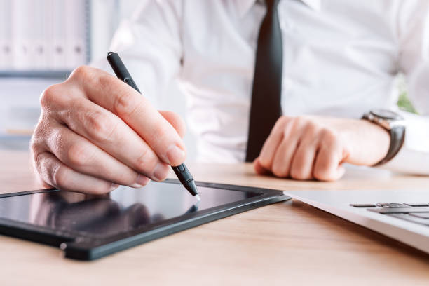 istock Electronic signature, businessman providing e-signature for document agreement using stylus and pad 1370871263