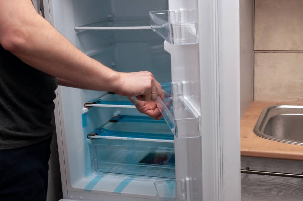 istock A man installs a shelf in a new refrigerator 1370872028