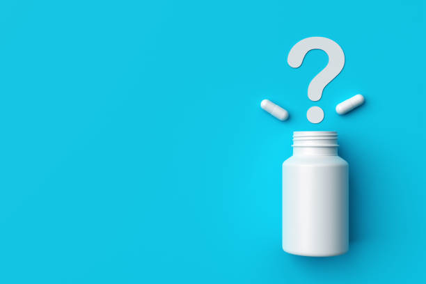 istock Plastic medical container and white capsule pills with question mark on blue background top view. 1370872124