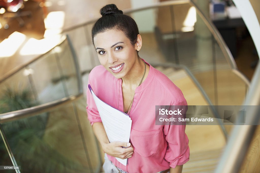 Portrait de sourire Femme d'affaires avec des documents sur les escaliers dans - Photo de 25-29 ans libre de droits