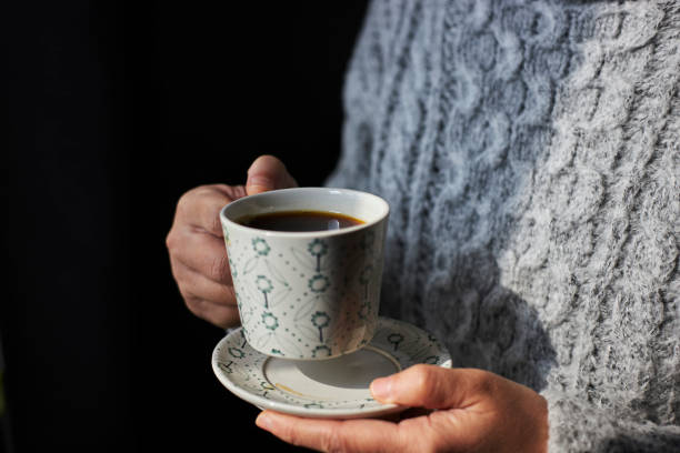 istock person holding a cup of coffee 1370872260