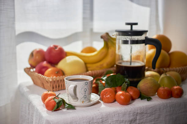 fresh fruits and coffee on table beside window
