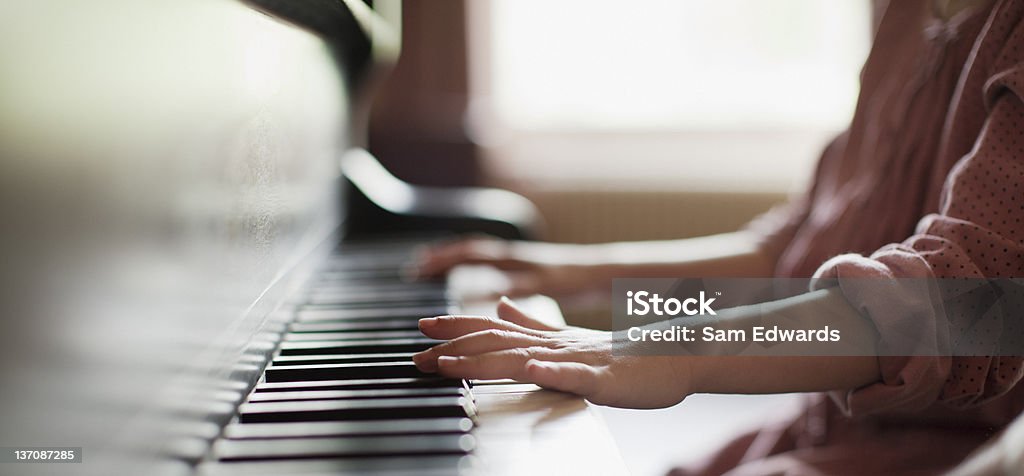 Close up of girl's hands on piano  Piano Stock Photo