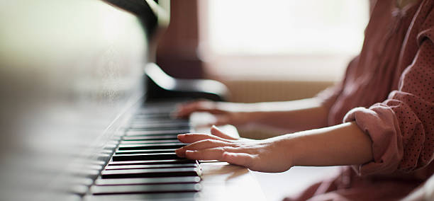Close up of girl's hands on piano  piano photos stock pictures, royalty-free photos & images