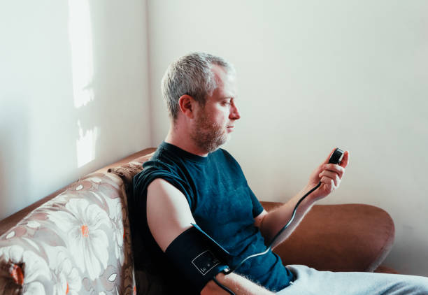 istock Man checking blood pressure at home 1370873627