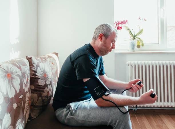 istock Man checking blood pressure at home 1370873652