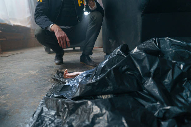 istock A corpse under black plastic bag at the crime scene with a female hand peeking out from under it 1370873822