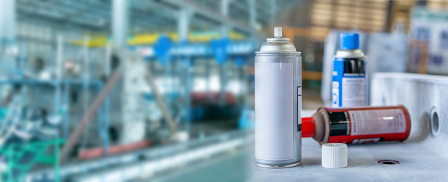 Cans of spray Penetrant Testing on  material steel and blur factory in background, panorama and blur concept photo for texture and copy space
