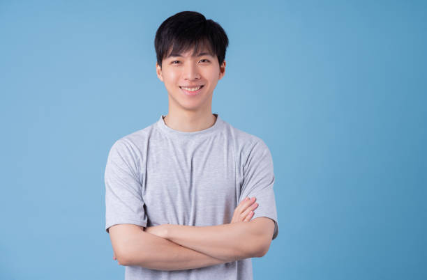 istock Young Asian man posing on blue background 1370873963