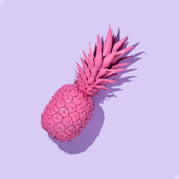 istock Creative layout with bright pink painted pineapple on pastel purple background. Trendy fruit concept. Minimal food colorful idea. 1370874046