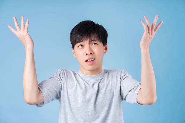istock Young Asian man posing on blue background 1370874048