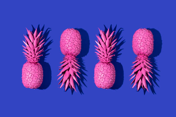 istock Creative pattern with bright pink painted pineapples on deep blue background. Trendy fruit concept. Minimal food colorful idea. 1370874063