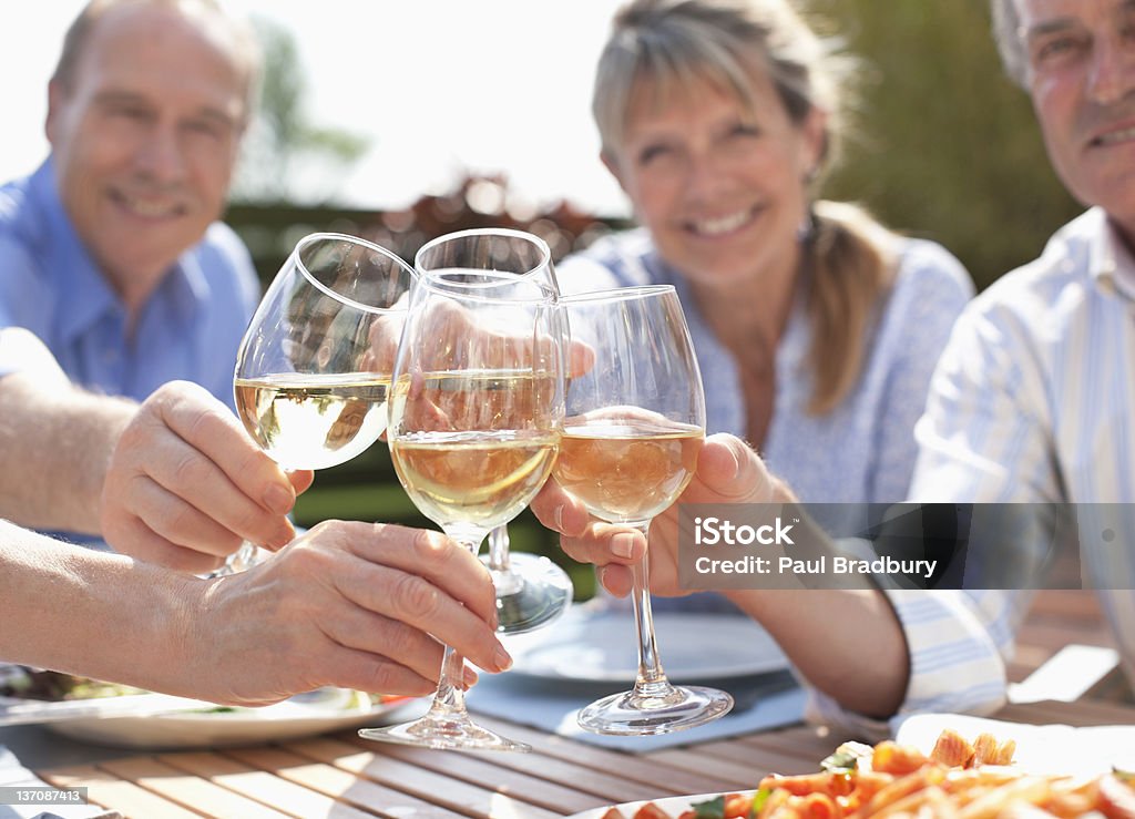Portret uśmiechnięta starsze pary opiekania wina szklanki w tabl - Zbiór zdjęć royalty-free (Białe wino)