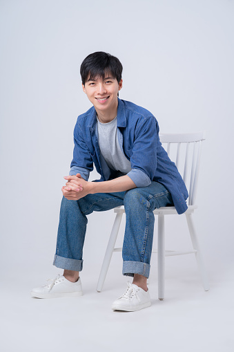 Young Asian man sitting on white background