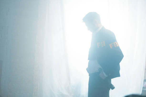 istock FBI agent in a a daylight, coming trough the big window, covered with a white curtain 1370875280