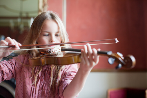 Back side of Woman holding violin and bow in hand,prepare for practice,blurry light around