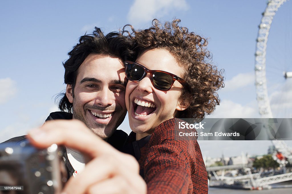 Glückliches Paar Selfie Selbstportrait mit Digitalkamera nahe ferri - Lizenzfrei London Eye-Riesenrad Stock-Foto