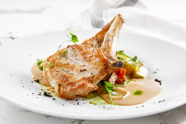istock Roasted pork steak with vegetables garnish and sauce. Bone-in ribeye pork chops. Main course of pork in rustic style. 1370877470