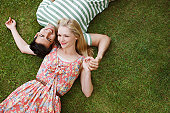 Young couple laying in grass and holding hands