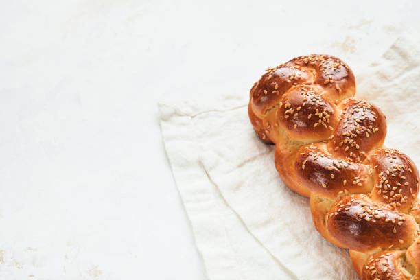 istock Challah bread. Sabbath kiddush ceremony composition. Freshly baked homemade braided challah bread for Shabbat and Holidays on white background, Shabbat Shalom. Top view. Copy space. 1370879101
