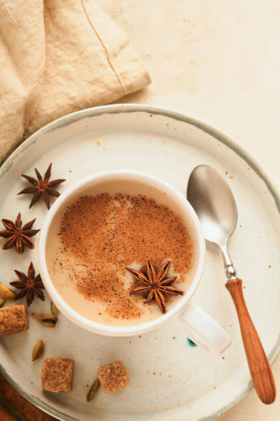 masala tee. masala chai gewürzter tee mit milch und gewürzen auf hellwarmem beigem hintergrund. traditionelles indisches getränk. gewürztee. speicherplatz kopieren. draufsicht. - star anise stock-fotos und bilder