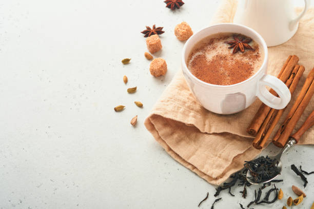 masala tee. masala chai gewürzter tee mit milch und gewürzen auf hellgrauem hintergrund. traditionelles indisches getränk. gewürzgetränk. speicherplatz kopieren. selektiver fokus. - star anise stock-fotos und bilder