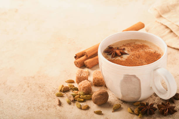 masala tee. masala chai gewürzter tee mit milch und gewürzen auf hellwarmem beigem hintergrund. traditionelles indisches getränk. speicherplatz kopieren. selektiver fokus. - star anise stock-fotos und bilder