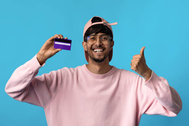 istock Cheerful indian man showing credit card and thumb up 1370880500