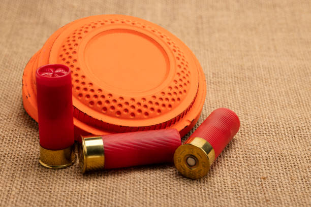 istock Clay shooting target with shotgun shell on burlap background , Shotgun game 1370882144
