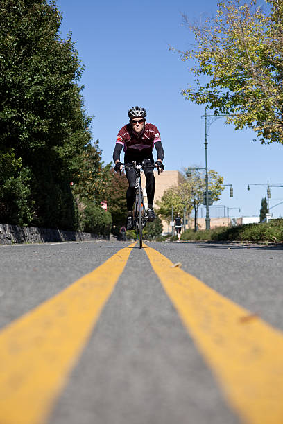 uomo in bicicletta tra due linee gialla - racing bicycle bicycle cycling yellow foto e immagini stock