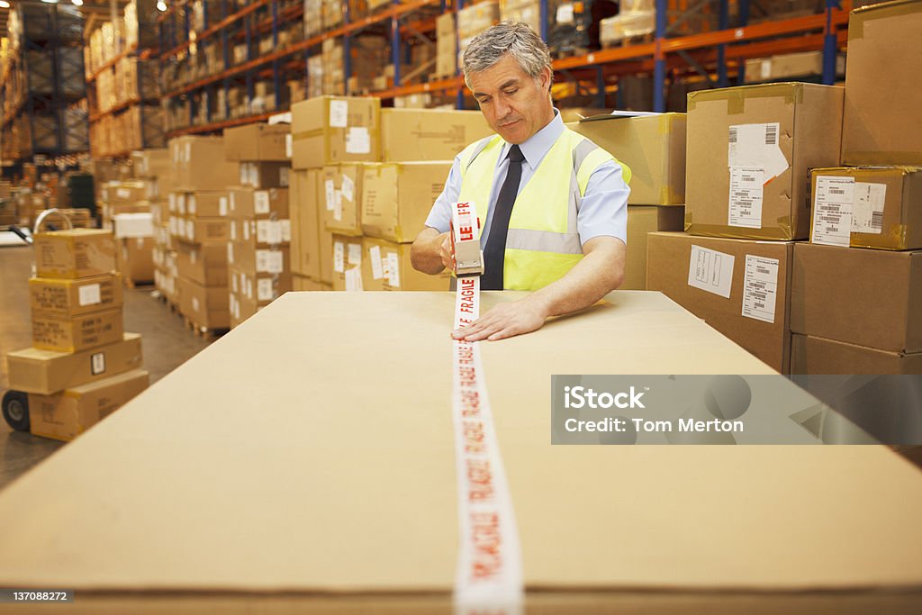 Cinta de trabajadores en almacén - Foto de stock de Almacén libre de derechos