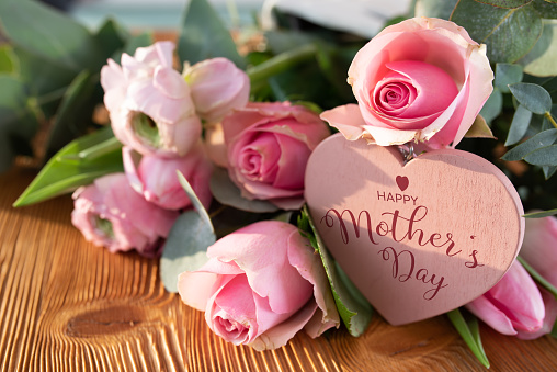Tarjeta del día de las madres con flores rosadas y corazón photo