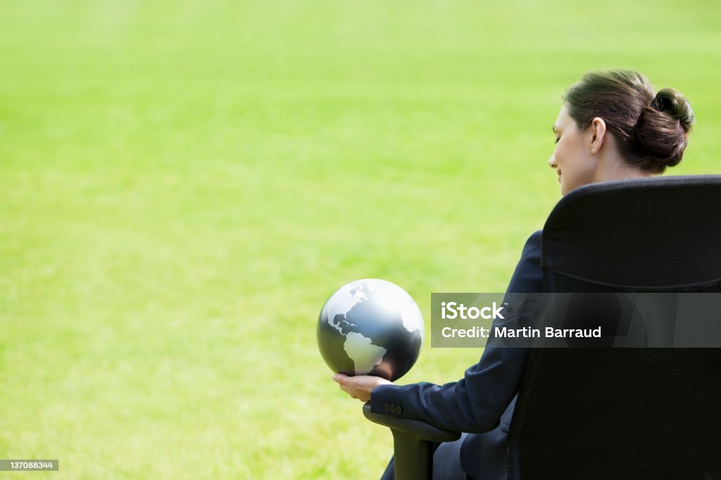 Businesswoman holding mundo de estar al aire libre - Foto de stock de Bien vestido libre de derechos