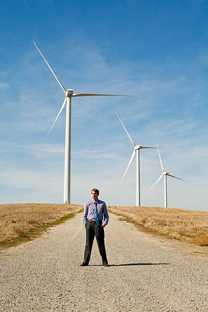 homme en face de turbines de vent - dry white blue northern california photos et images de collection