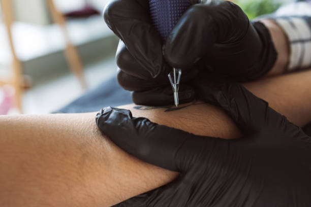 istock closeup of a tattoo machine, tattooing an arm 1370885143