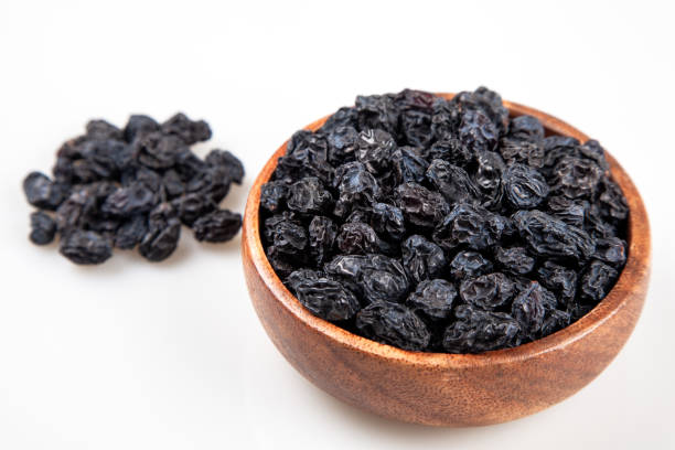 black raisins of full bowl on white background - fruit front view isolated berry fruit imagens e fotografias de stock