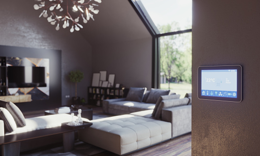 Smart home control tablet standing on the wall of the living room interior on sunny day. (3d render)