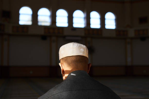 Back view of a young Muslim man's head while he prays in a mosque