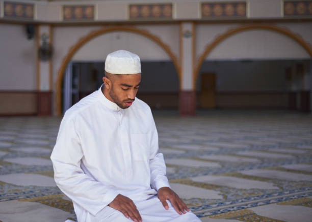 istock A young Muslim man bows his head in prayer while kneeling in a mosque 1370886579