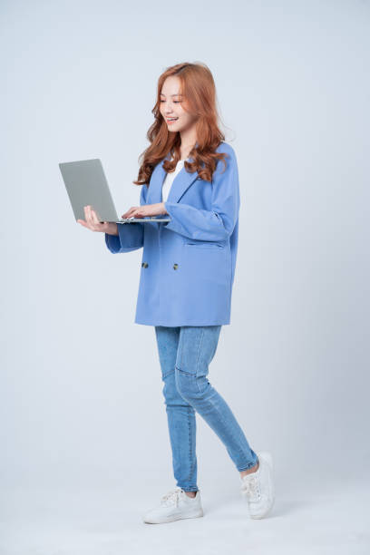 joven empresaria asiática usando computadora portátil sobre fondo blanco - female young women red hair full length fotografías e imágenes de stock