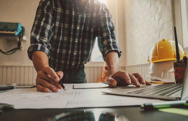 istock Male engineer working draw a blueprint on his desk. 1370888962