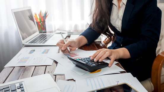 Businesswoman working finance with calculator in office.