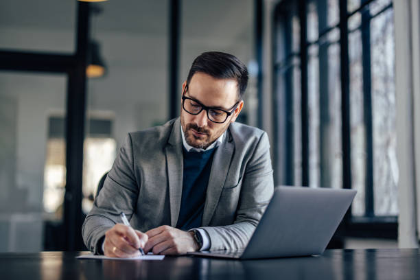 istock Focused caucasian executive, copying his notes from the laptop. 1370889188