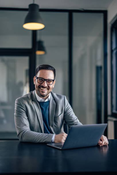 Portrait of happy caucasian man, smiling for the camera while working in the office. stock photo