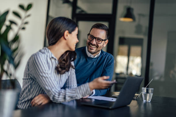 istock Delighted office workers, smiling and looking at each other, working in the conference room. 1370889570
