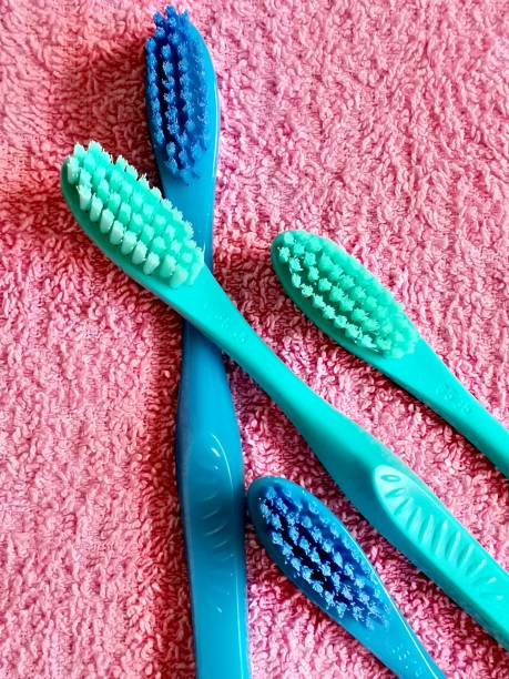 istock Four toothbrushes in blue tones lying on a pink towel. 1370889592