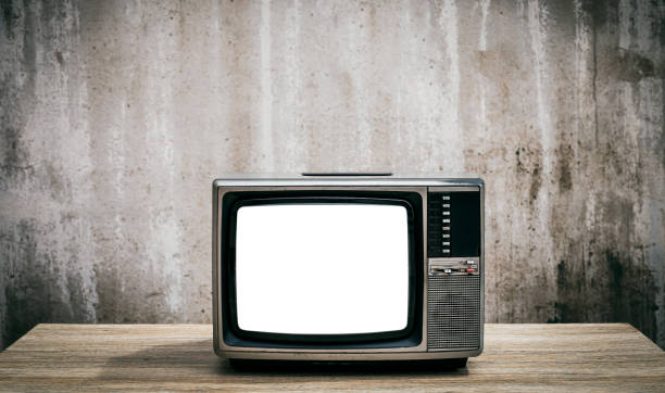 istock Retro old television cut out screen on wooden table with concrete wall background. 1370889726